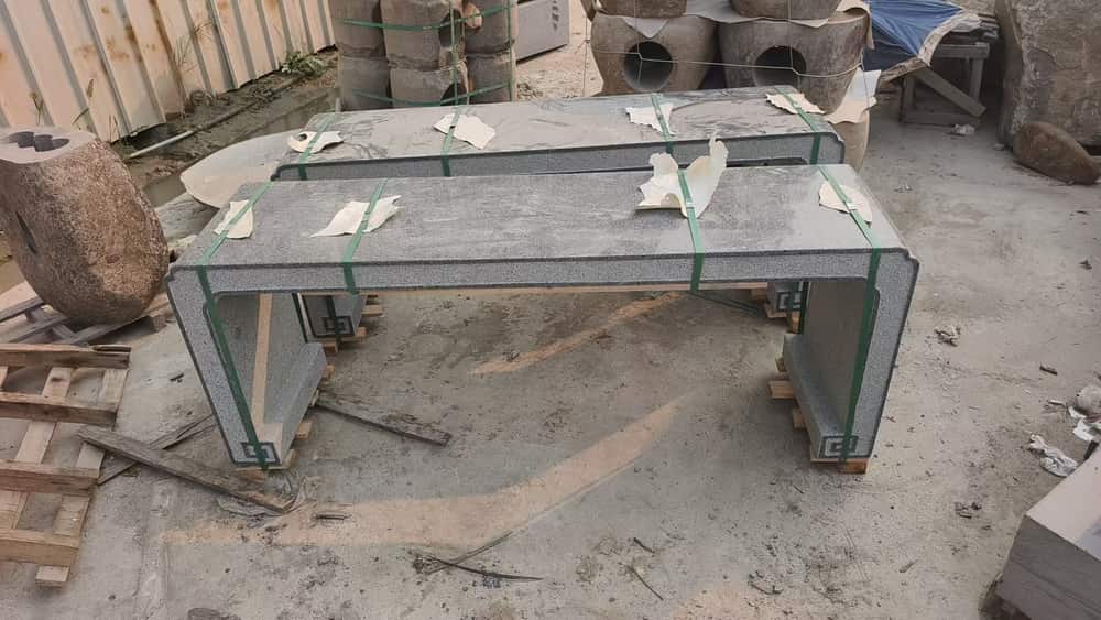 Long stone bench slab supported on workshop stands before finishing