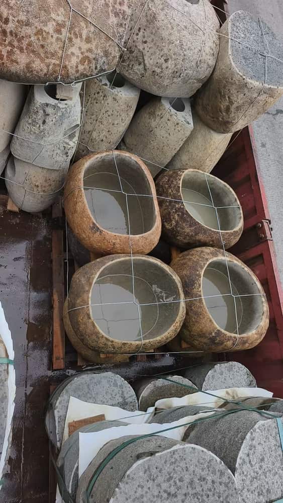 Assorted natural stone basins arranged in the factory storage area