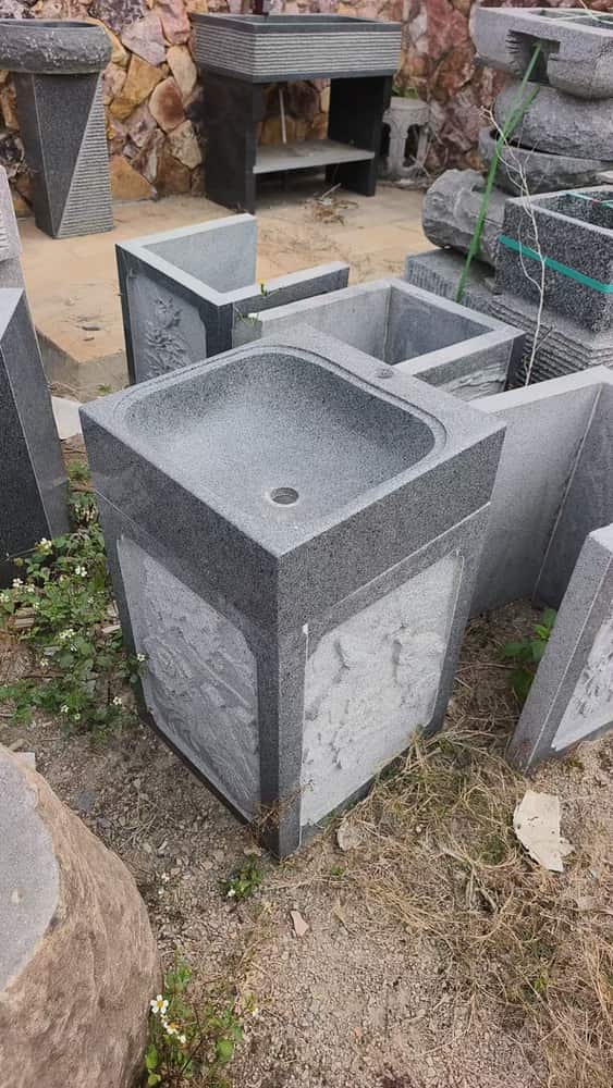 Custom rectangular stone wash basins arranged in a workshop yard
